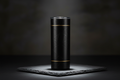 Sleek matte black minimalist tumbler with gold accent lines on dark slate surface